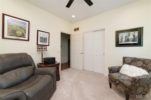 living area featuring light colored carpet, a ceiling fan, baseboards, and recessed lighting
