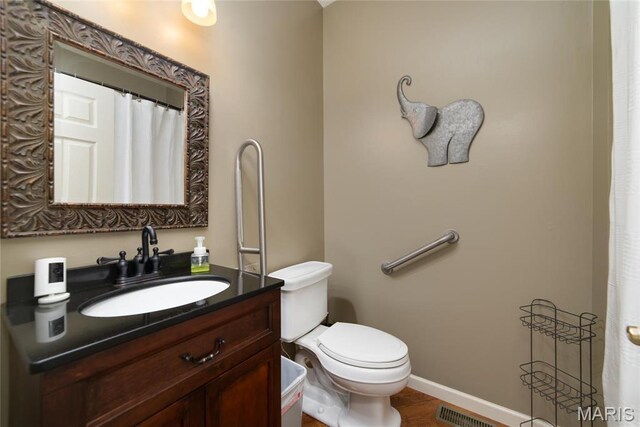 full bathroom featuring toilet, vanity, and baseboards