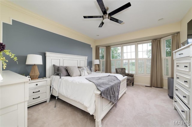 bedroom featuring light carpet, multiple windows, and ceiling fan