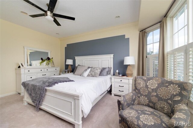 bedroom with light colored carpet, ornamental molding, and ceiling fan