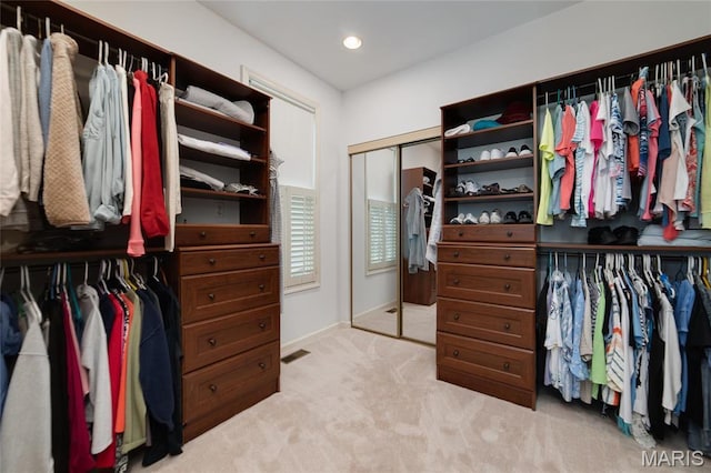 walk in closet featuring light carpet