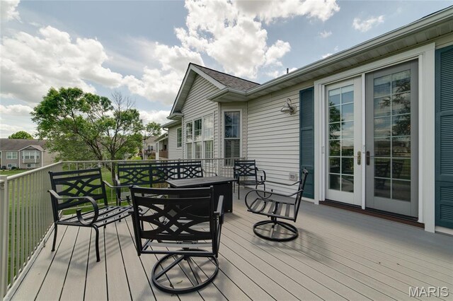 wooden terrace with outdoor dining space and french doors