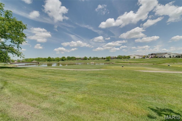 view of property's community with a water view and a yard