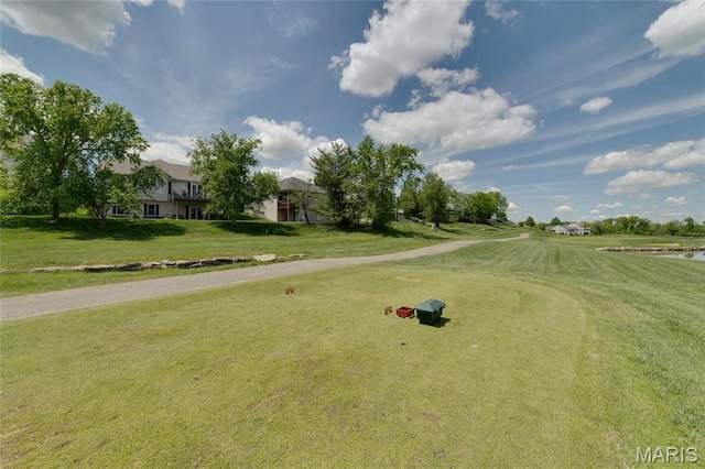 surrounding community featuring view of golf course, a yard, and a water view