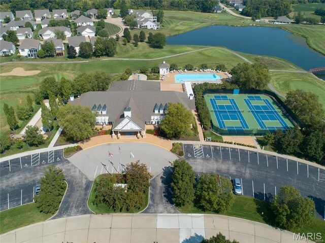 drone / aerial view of a nearby body of water and a golf course