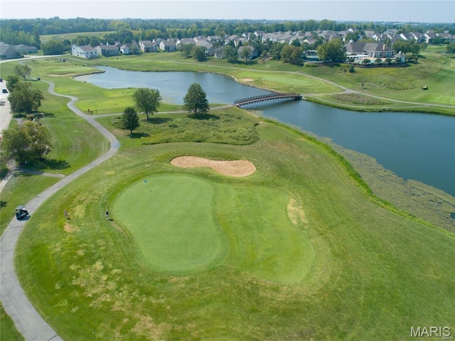 view of property location featuring a nearby body of water, nearby suburban area, and a golf club