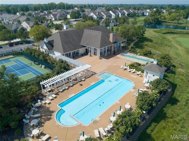 aerial perspective of suburban area with a pool area and a large body of water