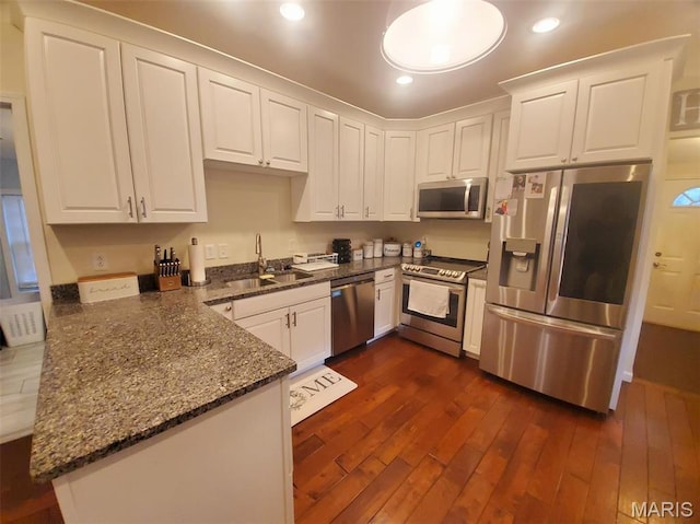 511 Grant St, Canton, MO 63435 - kitchen featuring stainless steel appliances, a sink, white cabinets, dark wood-type flooring, and dark stone countertops