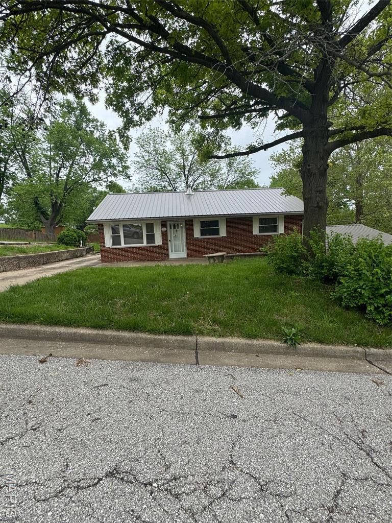 24 James Dr, Saint Charles, MO 63301 - ranch-style home featuring brick siding, a front lawn, and metal roof