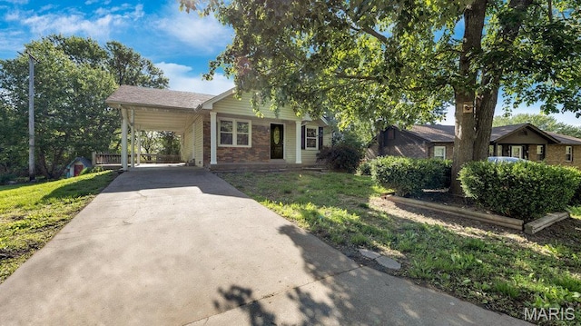 939 Vosholl Ave, Warrenton, MO 63383 - view of front of home with brick siding, concrete driveway, a front lawn, and a carport