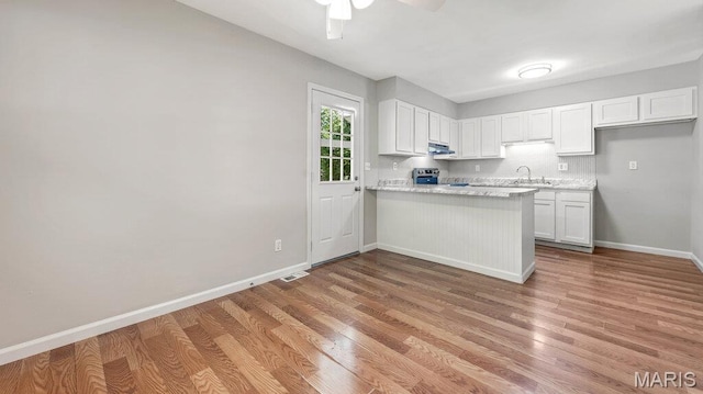 939 Vosholl Ave, Warrenton, MO 63383 - kitchen with stainless steel electric range oven, white cabinets, under cabinet range hood, and light wood-style flooring