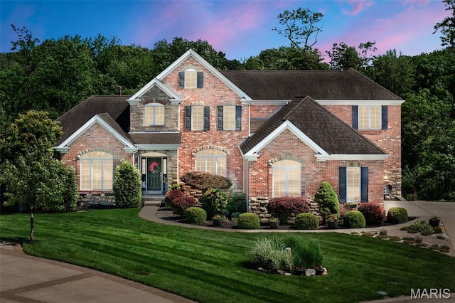 210 Oceanis Dr, Lake St Louis, MO 63367 - view of front of property with brick siding, a yard, and a shingled roof