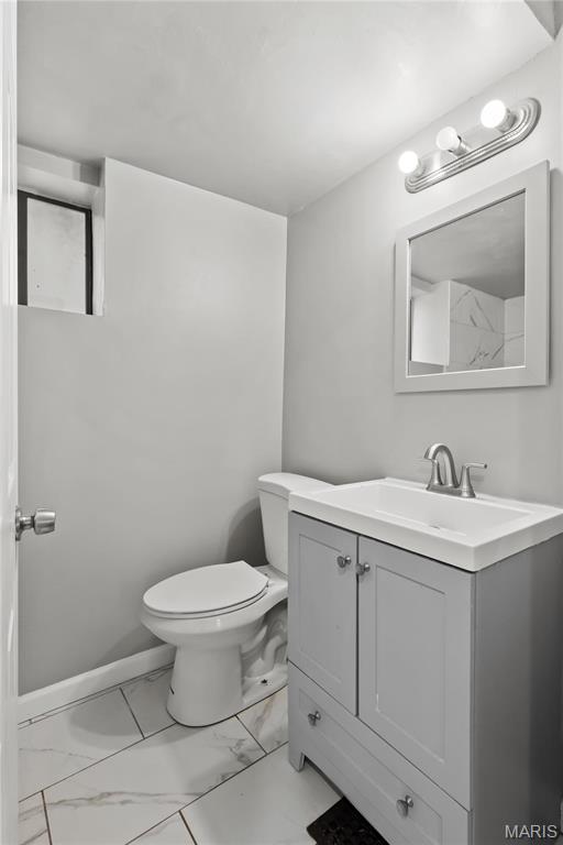 1016 Tamm Ave, Saint Louis, MO 63139 - bathroom featuring marble look tiles, toilet, and vanity