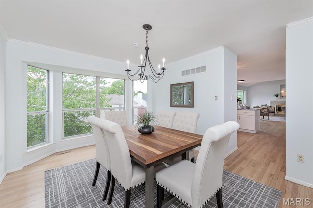 200 Kylewood Ct, Ballwin, MO 63021 - dining area featuring a chandelier, crown molding, light wood-style flooring, and baseboards