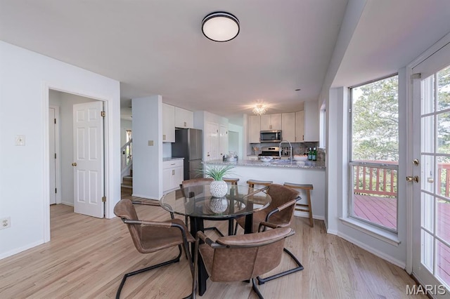 200 Kylewood Ct, Ballwin, MO 63021 - dining space featuring light wood finished floors, baseboards, and stairway
