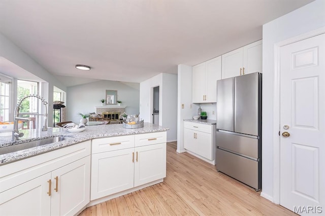 200 Kylewood Ct, Ballwin, MO 63021 - kitchen featuring freestanding refrigerator, a sink, light wood-type flooring, white cabinets, and light stone countertops