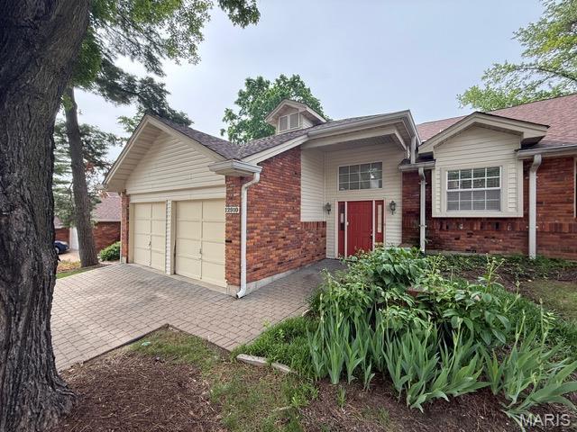 12910 Autumn View Dr, Saint Louis, MO 63146 - view of front facade with brick siding, a garage, and decorative driveway