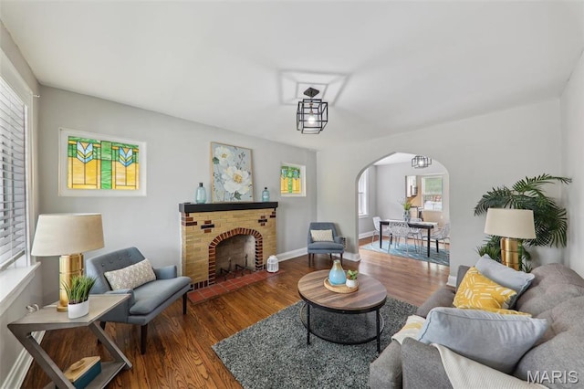 5909 Hampton Ave, Saint Louis, MO 63109 - living area with arched walkways, wood finished floors, plenty of natural light, and a fireplace