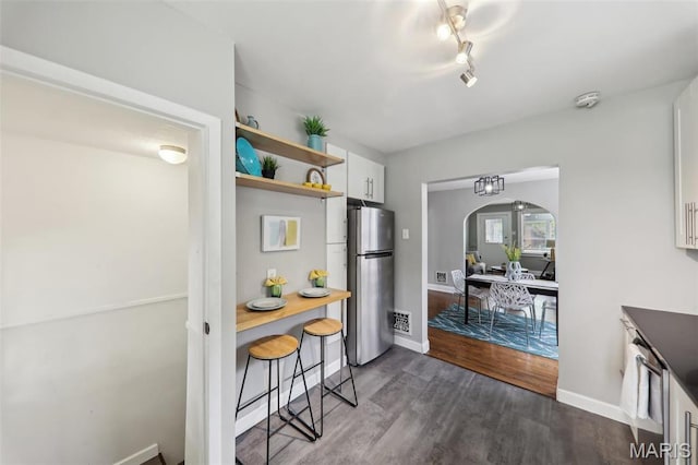 5909 Hampton Ave, Saint Louis, MO 63109 - kitchen with freestanding refrigerator, white cabinets, open shelves, dark wood-type flooring, and arched walkways