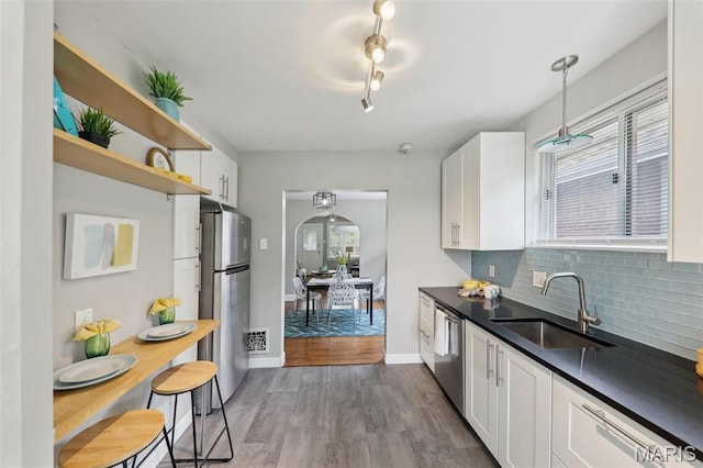 5909 Hampton Ave, Saint Louis, MO 63109 - kitchen with appliances with stainless steel finishes, a sink, dark countertops, and healthy amount of natural light