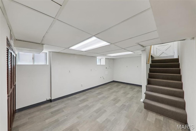 5909 Hampton Ave, Saint Louis, MO 63109 - basement with stairs, light wood-type flooring, baseboards, and a paneled ceiling