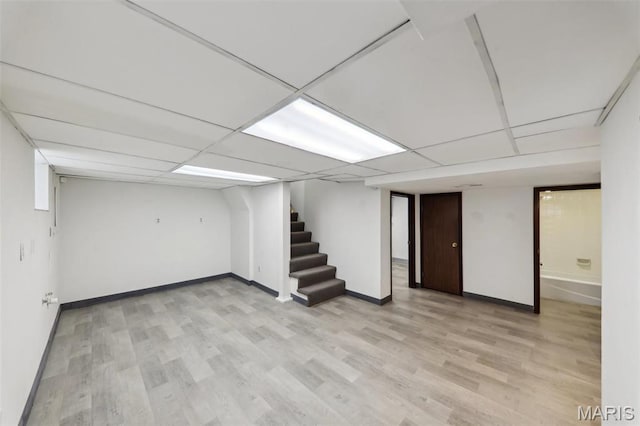 5909 Hampton Ave, Saint Louis, MO 63109 - finished below grade area featuring stairs, baseboards, light wood finished floors, and a paneled ceiling