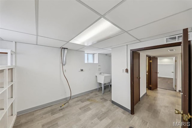 5909 Hampton Ave, Saint Louis, MO 63109 - basement featuring light wood finished floors, a paneled ceiling, and baseboards