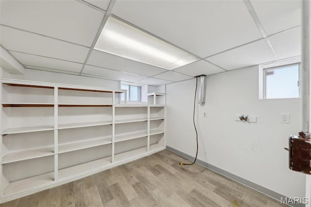 5909 Hampton Ave, Saint Louis, MO 63109 - below grade area featuring a paneled ceiling, wood finished floors, healthy amount of natural light, and baseboards