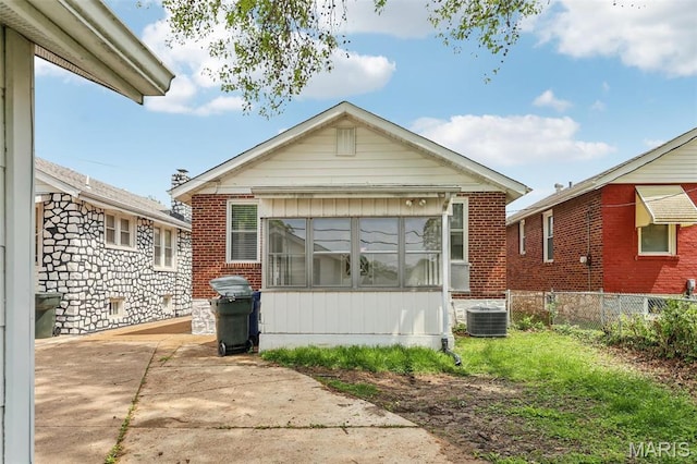 5909 Hampton Ave, Saint Louis, MO 63109 - view of front of home featuring a patio area, fence, central AC unit, and brick siding