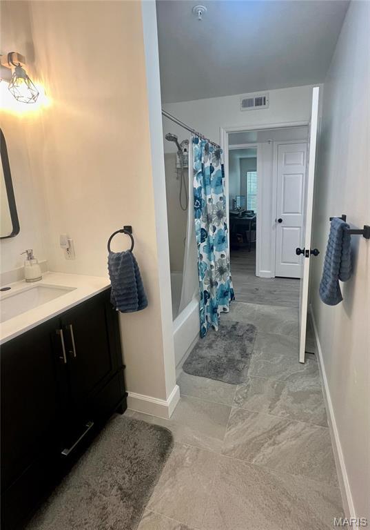 3605 Tracey Rich Rd Unit 1A, Saint Louis, MO 63125 - bathroom with vanity, shower / bathtub combination with curtain, and baseboards