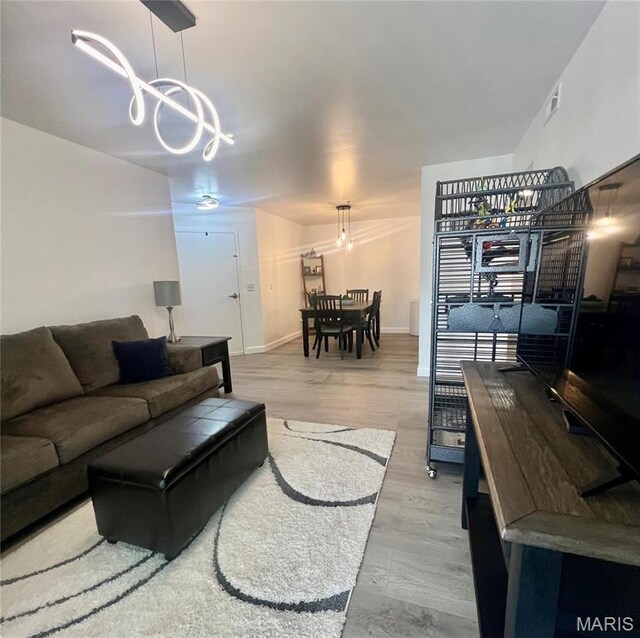 3605 Tracey Rich Rd Unit 1A, Saint Louis, MO 63125 - living area featuring a chandelier, wood finished floors, and baseboards