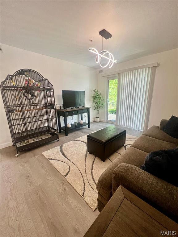 3605 Tracey Rich Rd Unit 1A, Saint Louis, MO 63125 - living room with baseboards, a chandelier, and wood finished floors