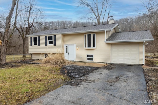 5604 Mark Trl, House Springs, MO 63051 - raised ranch featuring asphalt driveway, a shingled roof, a chimney, an attached garage, and fence