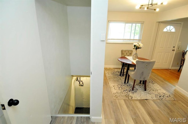 7051 Lansdowne Ave, Saint Louis, MO 63109 - dining room featuring wood finished floors, a chandelier, and baseboards
