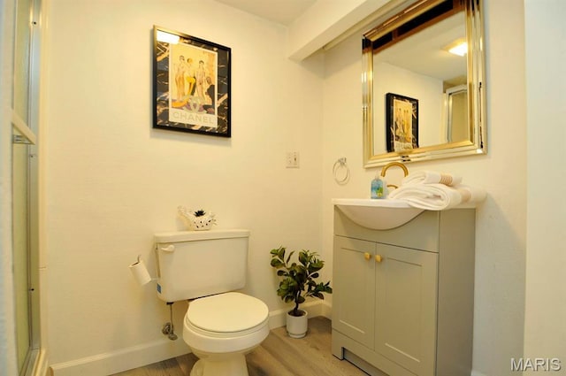 7051 Lansdowne Ave, Saint Louis, MO 63109 - bathroom with wood finished floors, baseboards, vanity, and toilet