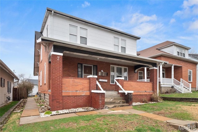 traditional style home with covered porch and brick siding