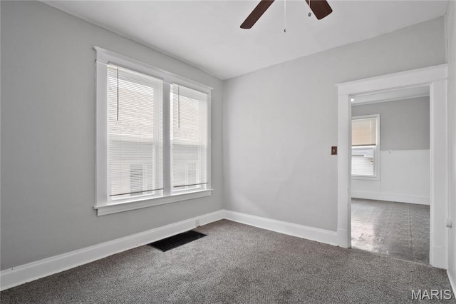 unfurnished room featuring ceiling fan, plenty of natural light, and carpet