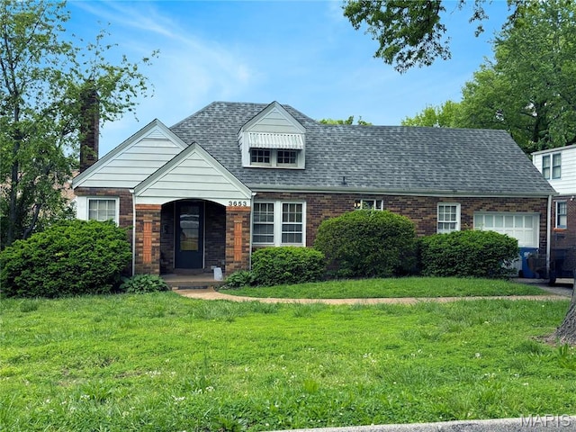 view of front of home featuring a front yard, brick siding, and a shingled roof