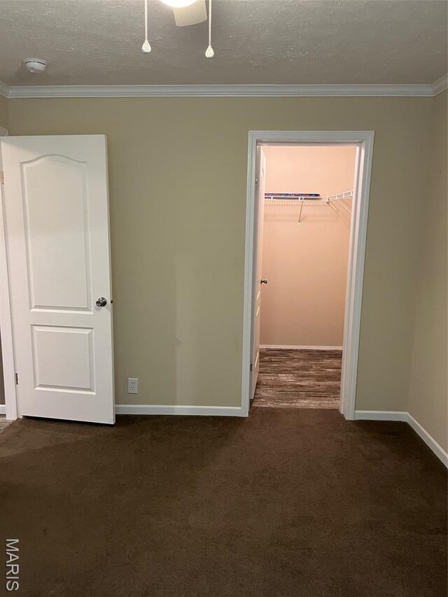 474 Bluffview Dr, Piedmont, MO 63957 - unfurnished bedroom featuring a spacious closet, dark carpet, baseboards, crown molding, and a closet