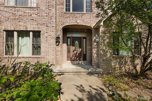 doorway to property featuring brick siding