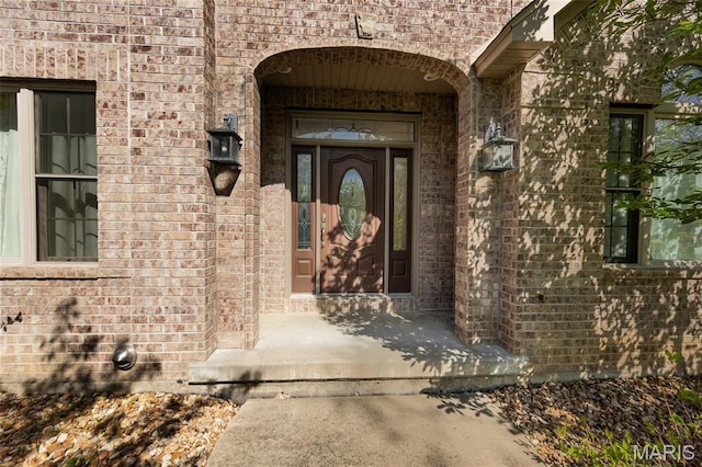 doorway to property featuring brick siding