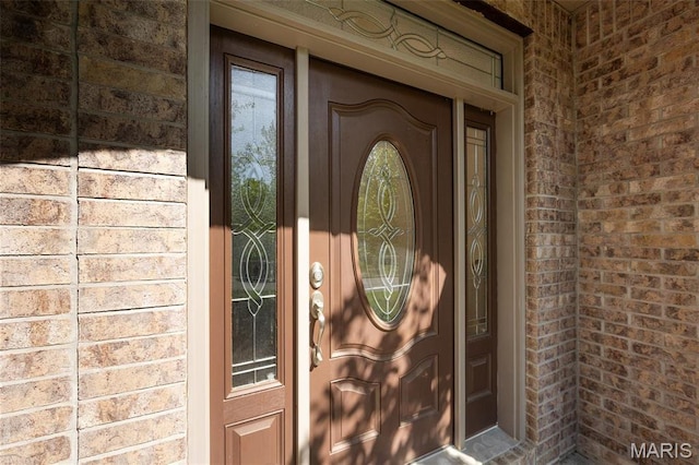 entrance to property featuring brick siding
