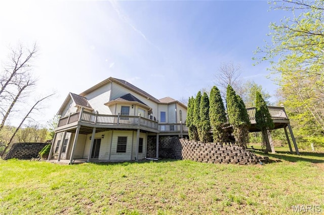 back of property with a wooden deck and a lawn