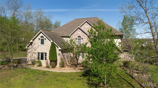 view of front of house featuring brick siding and a front yard