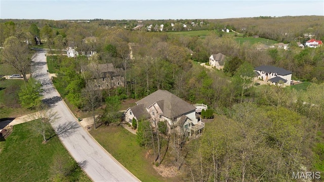aerial view of property and surrounding area with a heavily wooded area