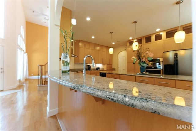 1025 Cobblestone Dr, Rolla, MO 65401 - kitchen featuring stainless steel refrigerator with ice dispenser, light stone counters, light wood-style floors, baseboards, and recessed lighting