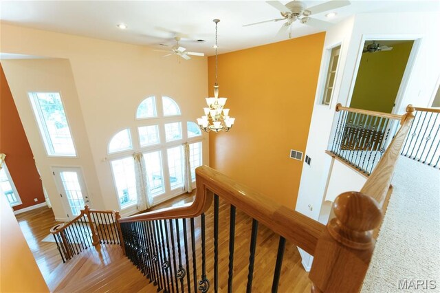1025 Cobblestone Dr, Rolla, MO 65401 - stairway featuring wood finished floors, a ceiling fan, a chandelier, recessed lighting, and a towering ceiling