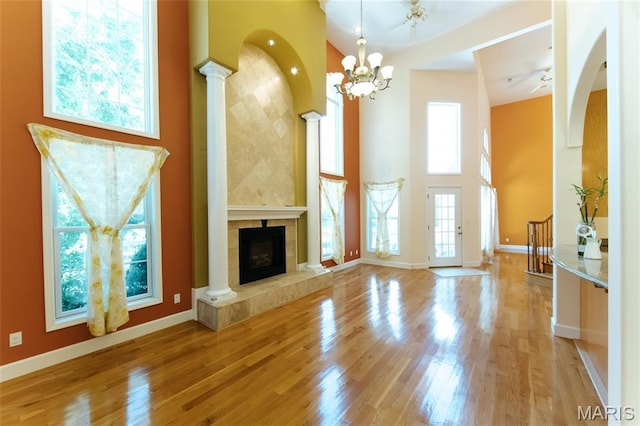 1025 Cobblestone Dr, Rolla, MO 65401 - unfurnished living room featuring a high ceiling, wood finished floors, decorative columns, baseboards, and a fireplace