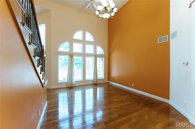 1025 Cobblestone Dr, Rolla, MO 65401 - empty room featuring a towering ceiling, wood finished floors, a chandelier, baseboards, and stairway