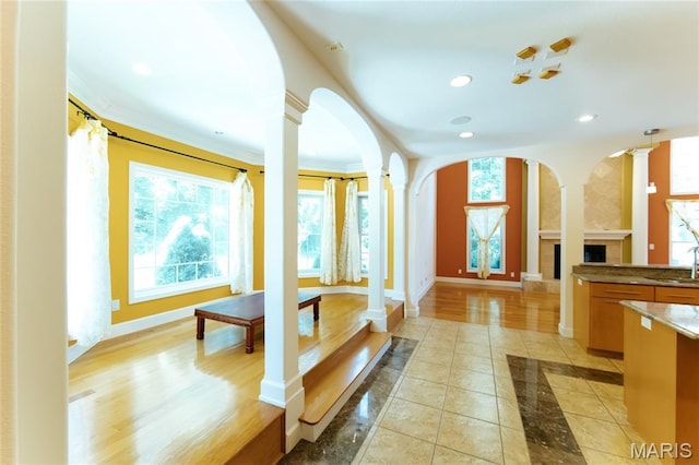 1025 Cobblestone Dr, Rolla, MO 65401 - unfurnished living room with decorative columns, a sink, healthy amount of natural light, baseboards, and recessed lighting